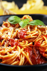 Plate of delicious spaghetti Bolognaise or Bolognese with savory minced beef and tomato sauce garnished with parmesan