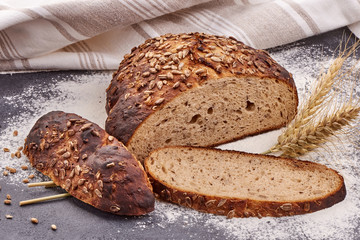 Round freshly baked rustic rye bread on a rustic background