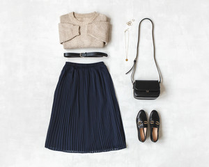 Blue midi pleated skirt, beige knitted sweater, small black cross body bag, belt, loafers (flat...