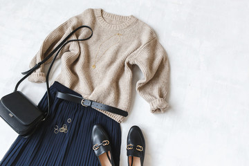 Blue midi pleated skirt, beige knitted sweater, small black cross body bag, belt, loafers (flat...