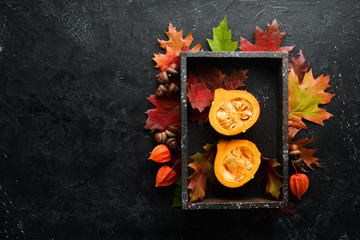 Fresh colored pumpkins in a wooden box. Autumn vegetables. flat lay. In the old background. Top view. Free space for your text.