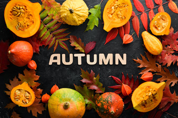 Autumn background with coffee, pumpkin, autumn leaves and seeds. flat lay. On a black stone background. Top view. Free space for your text.