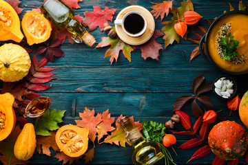 Autumn background with coffee, pumpkin, autumn leaves. flat lay. On a blue wooden background. Top view. Free space for your text.