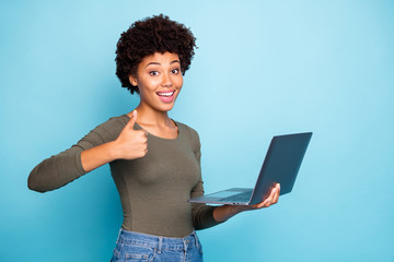 Portrait of funky funny afro american girl entrepreneur hold her laptop show thumb up recommend...