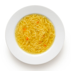 Instant chicken noodle soup in a white ceramic soup plate isolated on white. Top view.