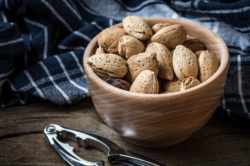 Almonds in-shell in wooden bowl.