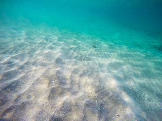 Fototapeta na wymiar Sandy bottom underwater in a turquoise ocean