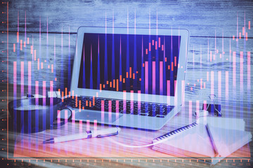 Double exposure of graph and financial info and work space with computer background. Concept of international online trading.