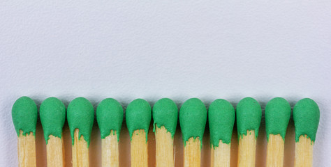 wooden matches with green sulphur on grey background with copy space closeup, top view