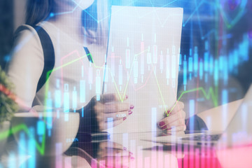 Double exposure of hands making notes with forex chart huds. Stock market concept.