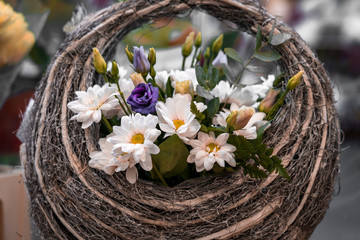 Fototapeta na wymiar bouquet of flowers in a basket on wooden table