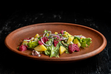 Boiled potatoes with dill and beetroot paste. Sprinkled with onions and capers.