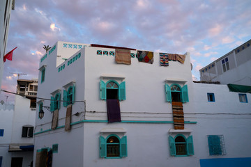 Moroccan carpets hanging on the facade of a carpet store in Asilah
