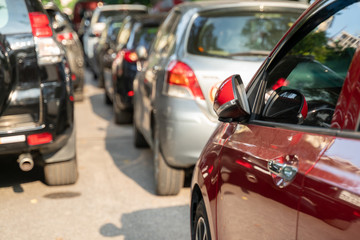 Long line of cars on urban street with rear view