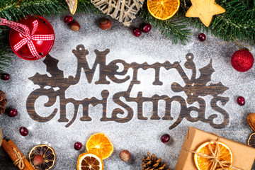 Merry Christmas sigh made out of sugar powder surrounded by Christmas holidays ornament, flat lay