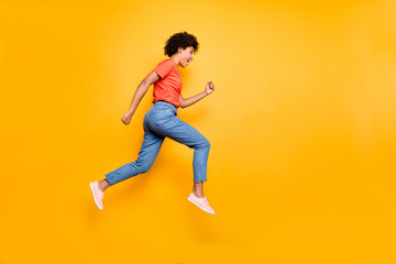 Hurry. Real sales. Full size profile side photo of funny funky cheerful woman jump run fast after discounts wear denim jeans sneakers red t-shirt isolated over yellow color background
