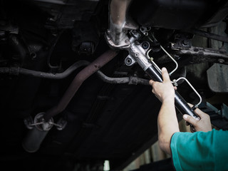 Hand of auto mechanic working in garage. Repair service Steering rack. - obrazy, fototapety, plakaty