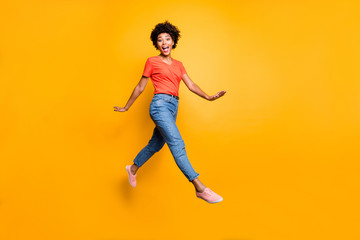 Fototapeta na wymiar Full body photo of funny funky cheerful lady jump go walk feel crazy have free time wear spring clothes sneakers isolated over yellow color background