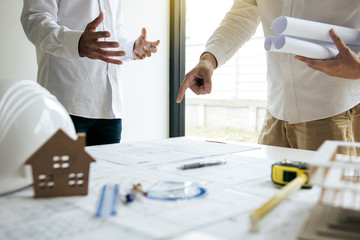 Team architect or engineering people standing working discussion together at a construction site.