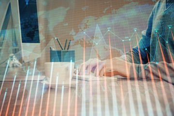 Multi exposure of graph with man typing on computer in office on background. Concept of hard work.