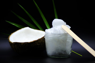 Geöffnete Kokosnuss mit Kokosöl im Glas 