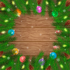 Christmas card. Frame of pine branches, cones and Christmas balls on a wooden board background. Empty space for your text.