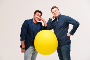 two men posing with big yellow ball