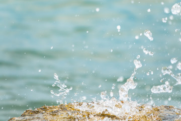Splashes and drops of water on a blue sea background.