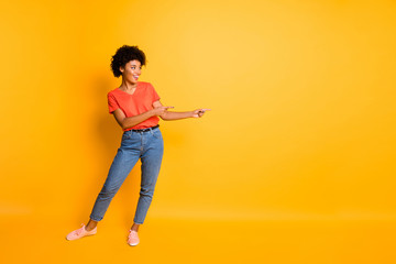 Fototapeta na wymiar Copyspace photo of cheerful charming trendy cute fascinating girlfriend pointing at something smiling toothily isolated over yellow bright color background