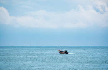 A fisherman is sailing in a boat.