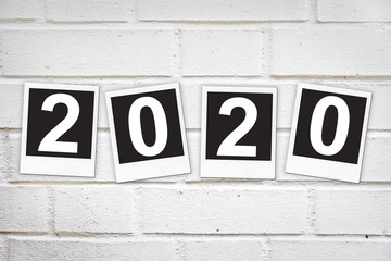 2020 in instant photo frames on a brick wall, new year greeting card