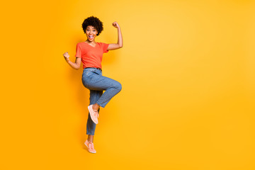 Fototapeta na wymiar Copyspace photo of cheerful charming cute nice curly pretty sweet attractive girlfriend black skinned wearing jeans denim t-shirt footwear rejoicing isolated over yellow color background