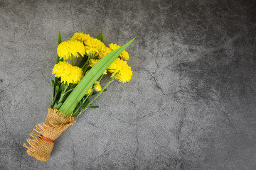 Bouquet yellow mum flowers spring and pandan wrapped in sack on dark plate background - Flowers respect