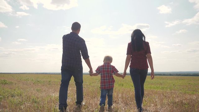 happy family walking nature teamwork friendship care concept slow motion video. father mom and son walk in nature sunset sunlight hold hand. happy family parents man and girl hold little boy a walking