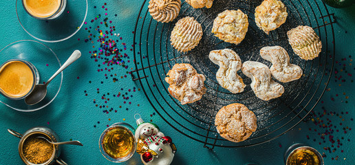 banner of different classic Italian homemade almond cookies with espresso coffee and glasses of sweet liquor on the table, New Year's Christmas decor