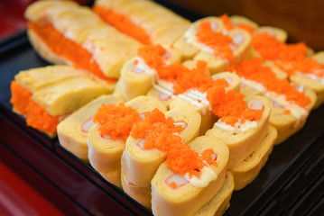 Sushi menu set Japanese cuisine fresh ingredients on tray - Japanese food sushi roll rice crab stick omelet with Tobiko egg is orange (flying fish roe) in the restaurant