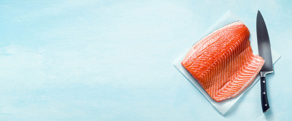 banner of Fresh salmon slice on a wooden cutting board with a chef's knife on the table. cooking...