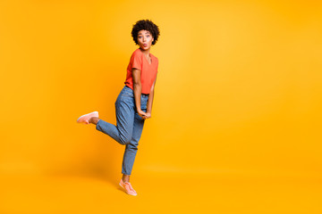 Fototapeta na wymiar Copyspace full length body size photo of charming cheerful cute lady kissing something through air space playfully running wearing jeans denim orange t-shirt isolated vivid color background