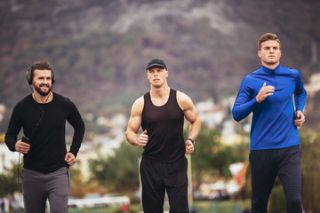 Young athletes practicing a run on athletics stadium track.