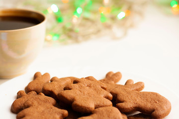 A Cup of coffee, Christmas chocolate cookies and a garland with lights