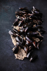 Fresh uncooked raw big mussels on dark background