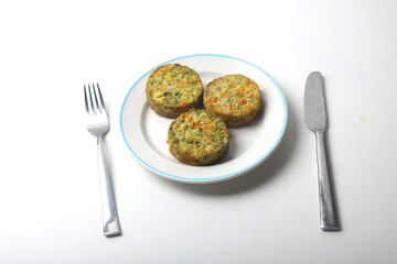vegetable cutlets on a plate and table-ware isolated on white background