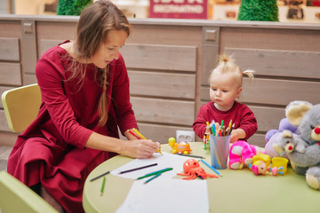 mom and daughter in the store play in the children's corner