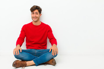 young handsome man with a big, friendly, carefree smile, looking positive, relaxed and happy,...