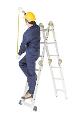 Handyman in uniform standing on ladder while using tape measure on white