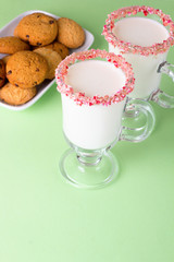 Two glasses of eggnog on green background. Traditional Christmas beverage.