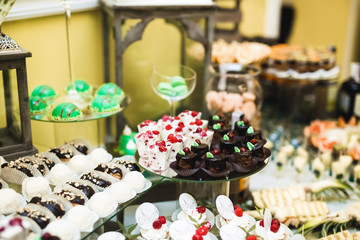 Delicious and tasty dessert table with cupcakes and shots at reception closeup