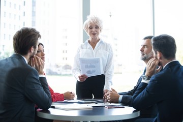 Mature businesswoman, business coach holding briefing, explaining project
