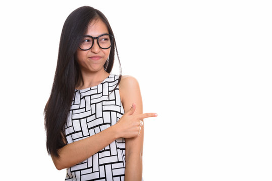 Young Asian teenage nerd girl pointing finger while looking disg