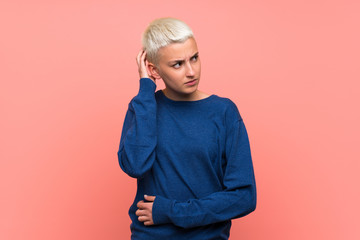 Teenager girl with white short hair over pink wall thinking an idea